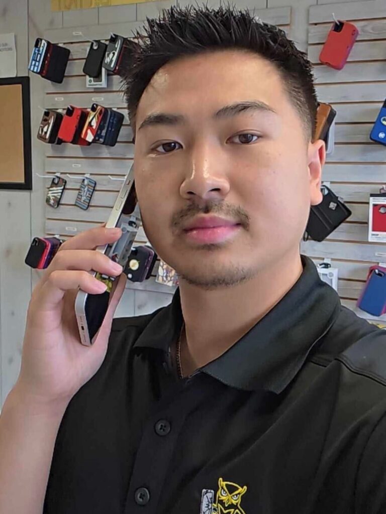 Scott Vo, Master Technician and Owner of Owl Repairs East Cobb, speaking on phone inside repair shop