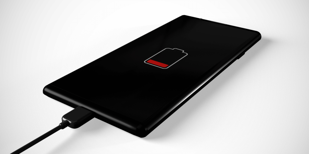 Smartphone with low battery icon while charging via USB cable, indicating slow charging issue